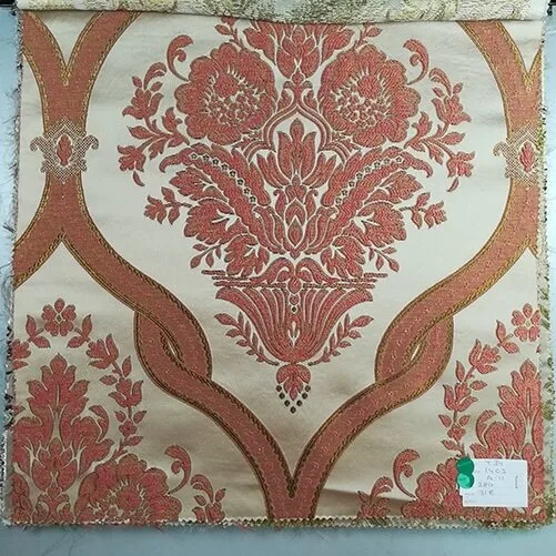 Tejido bordado con fondo liso y elegante damasco. Beige, marrón y rojo